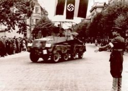 1941 m. birželio pabaigoje lietuviai patys išsikovojo laisvę, atkūrė tarpukario įstaigas ir palaikė tvarką krašte. Lietuvių policininkas rodo vokiečių kariuomenės šarvuočio įgulai kelią, kuriuo ji turi važiuoti.